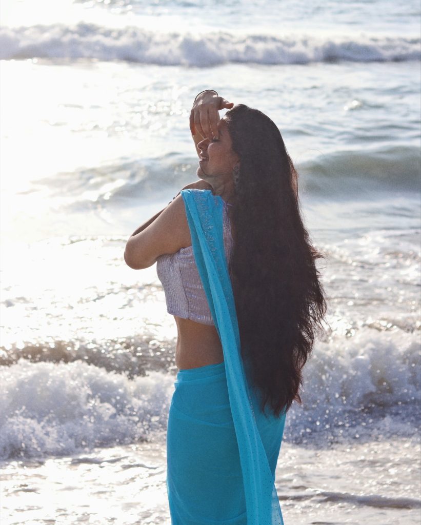 photoshoot captures Kanduri Sudha in traditional blue drape against ocean