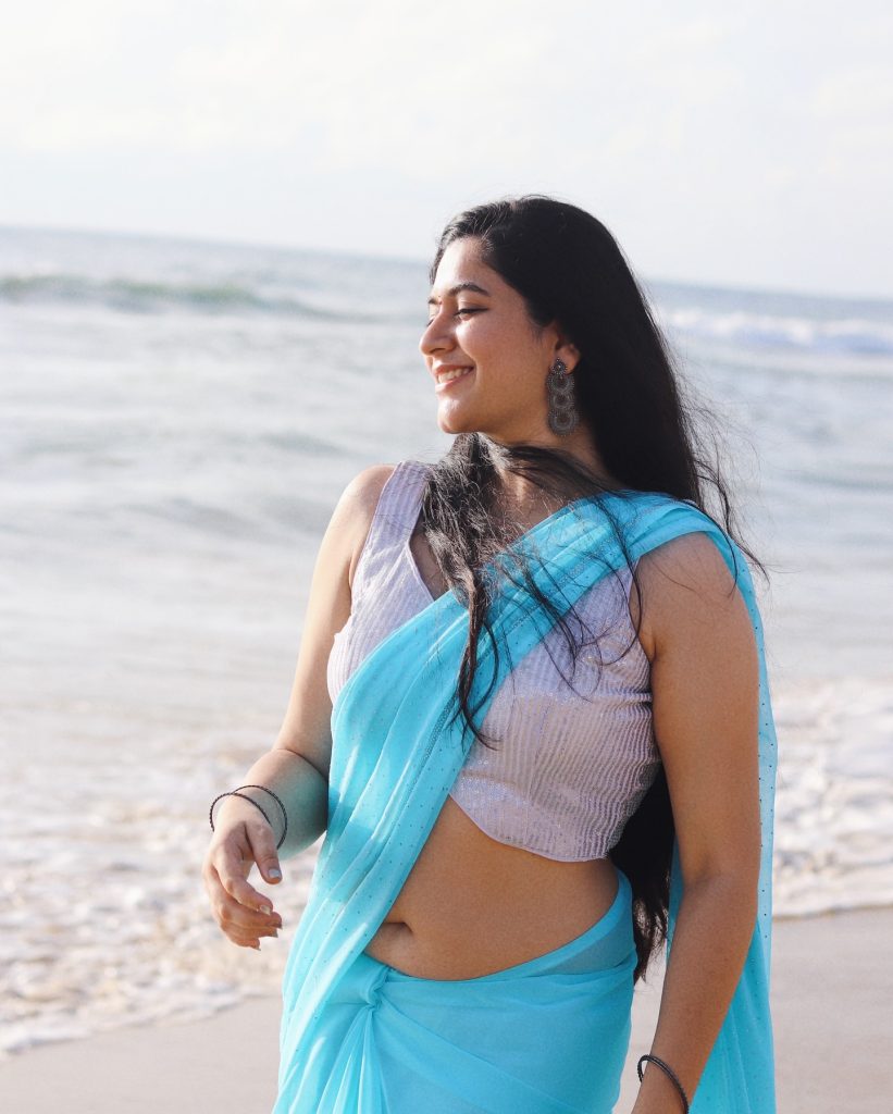 photoshoot captures Kanduri Sudha in traditional blue drape against ocean