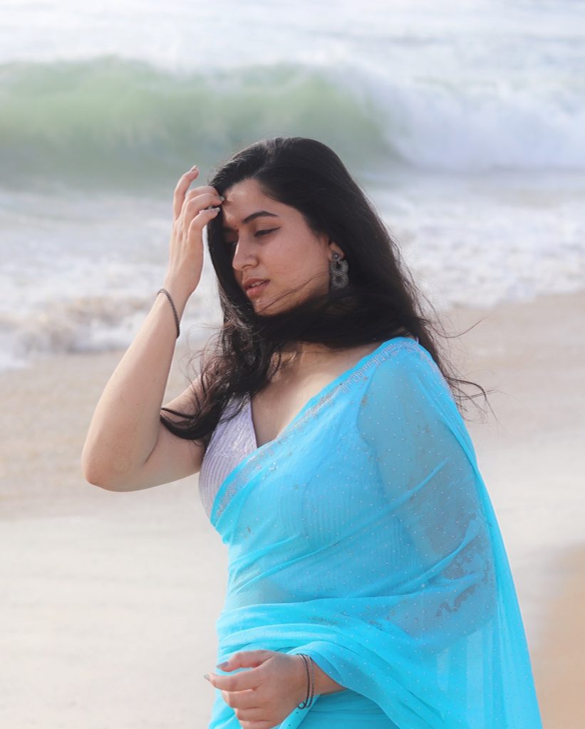 photoshoot captures Kanduri Sudha in traditional blue drape against ocean