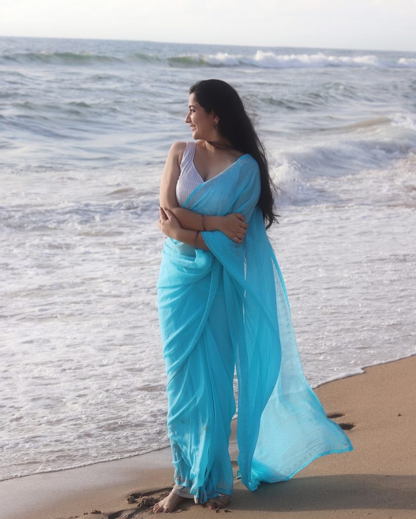 photoshoot captures Kanduri Sudha in traditional blue drape against ocean