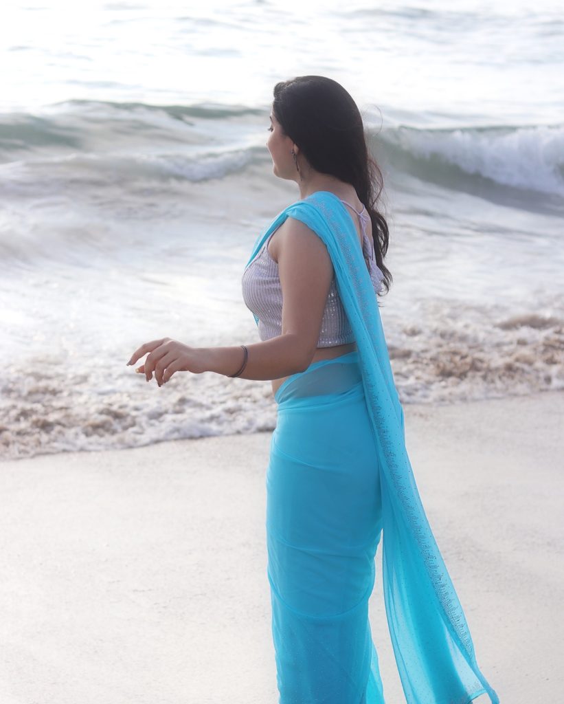 photoshoot captures Kanduri Sudha in traditional blue drape against ocean