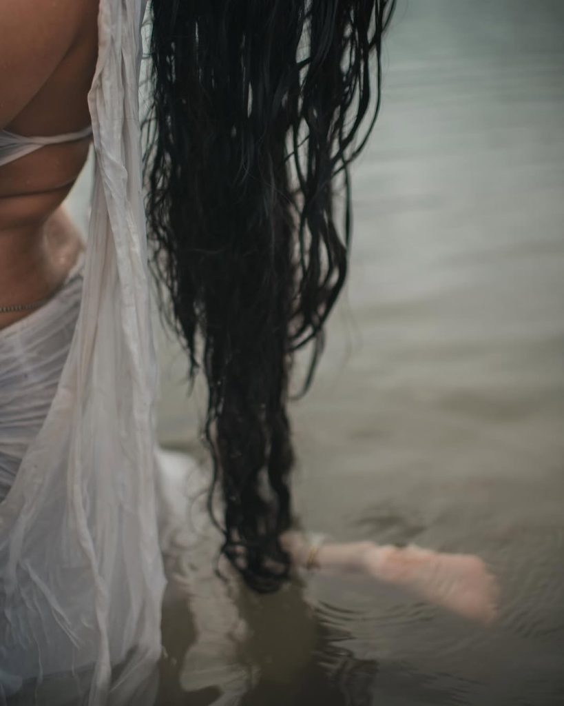Malavika embodies natural beauty in wet white saree with flowing water backdrop