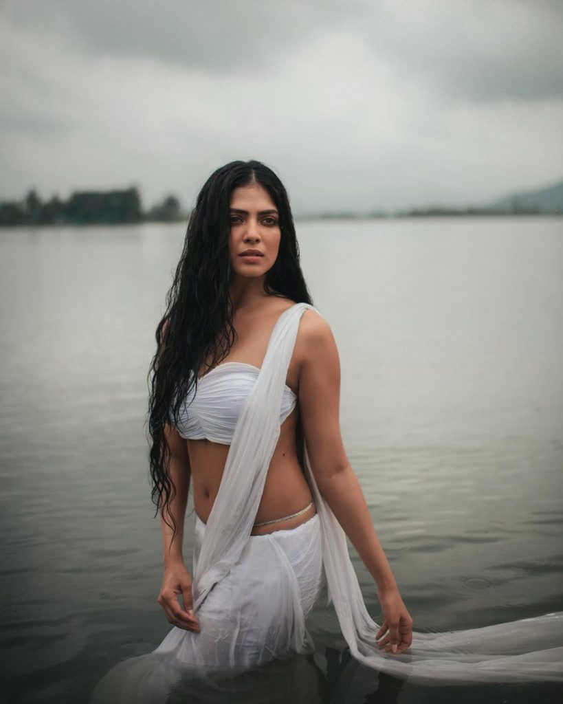 Malavika embodies natural beauty in wet white saree with flowing water backdrop