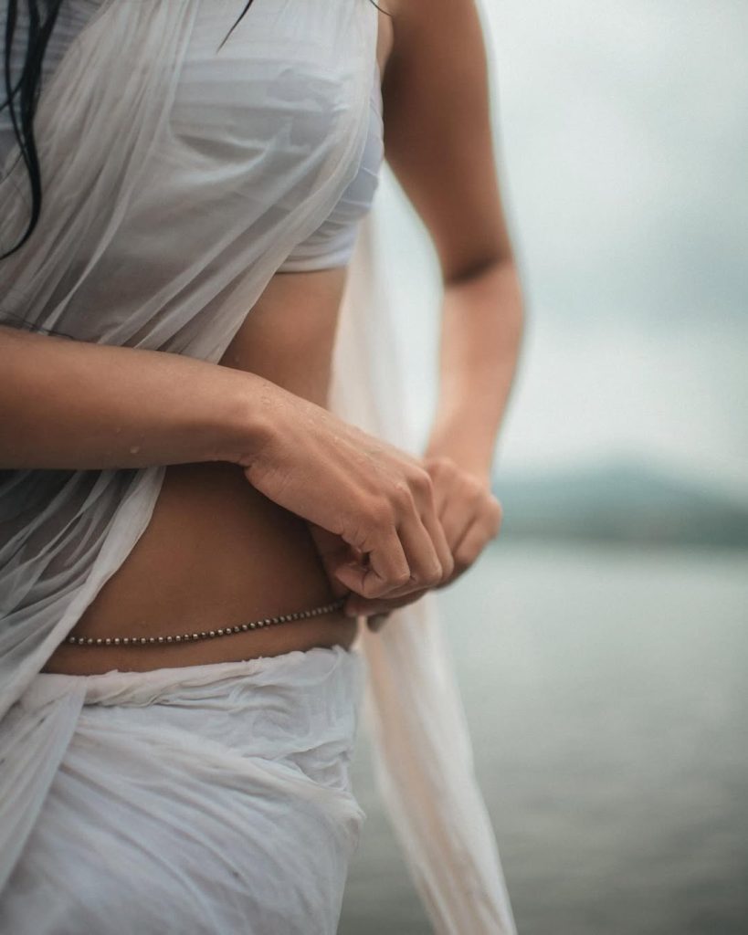Malavika embodies natural beauty in wet white saree with flowing water backdrop
