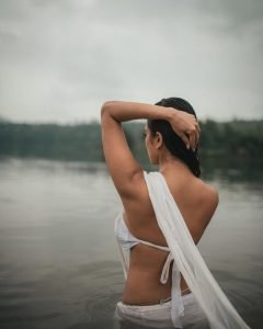 Malavika embodies natural beauty in wet white saree with flowing water backdrop