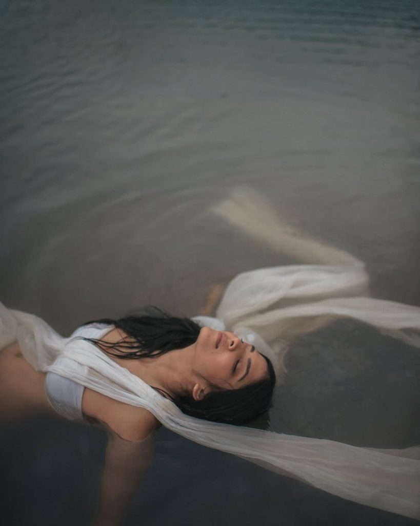 Water photography showcases Malavika's wet white saree's flowing elegance