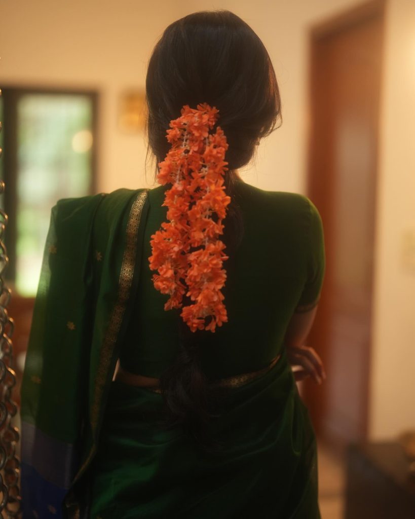 Emerald green saree fabric flows gracefully in Priyanka Mohan's elegant pose