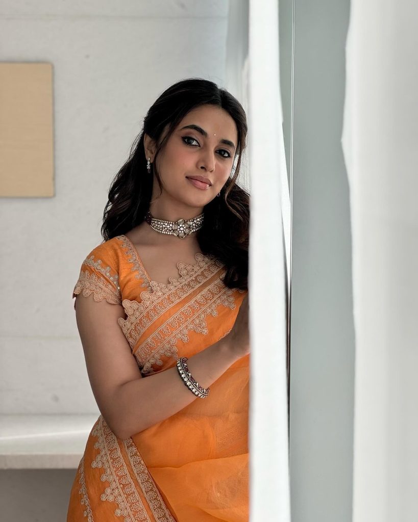 Brilliant orange saree creates dramatic visual impact in Priyanka Mohan's studio lighting