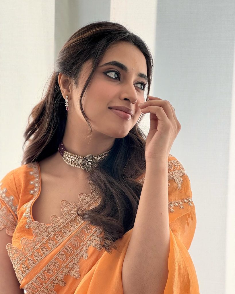 Brilliant orange saree creates dramatic visual impact in Priyanka Mohan's studio lighting