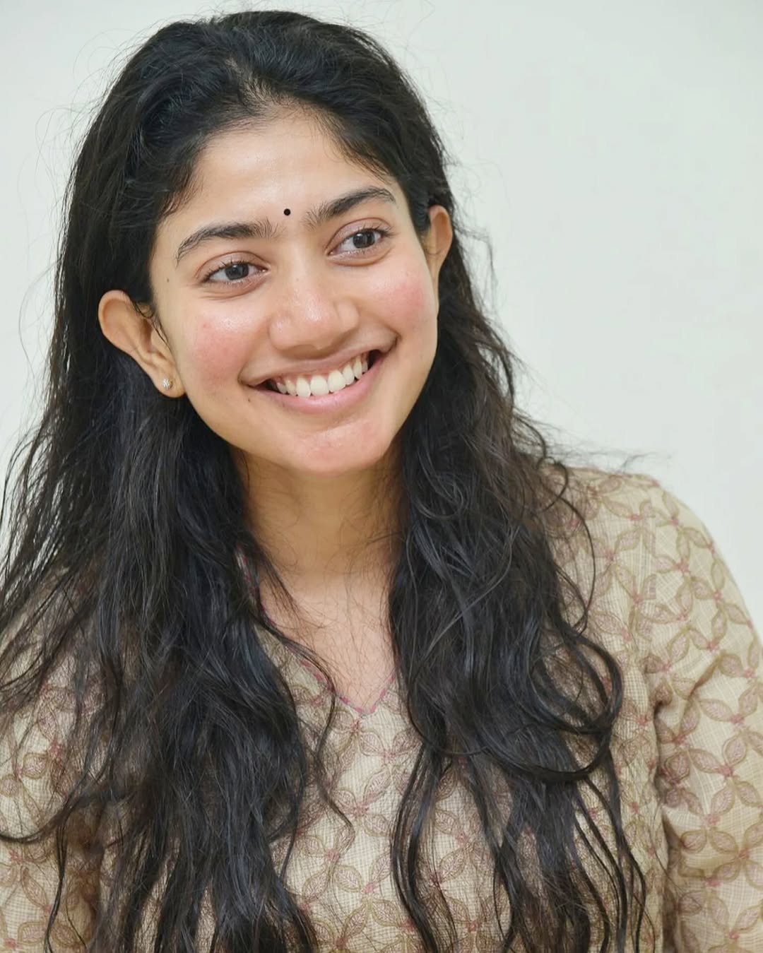Natural loose hair flows freely creating organic, authentic beauty for Sai Pallavi