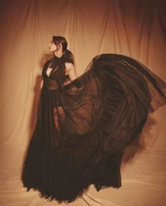 Black gown elegantly frames Tripti's moon-sun tattoo artistic expression