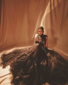 Black gown elegantly frames Tripti's moon-sun tattoo artistic expression