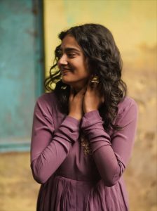 Casual outdoor setting showcases Yoga Lakshmi's elegant purple pleated gown