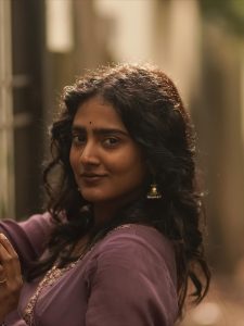 Casual outdoor setting showcases Yoga Lakshmi's elegant purple pleated gown