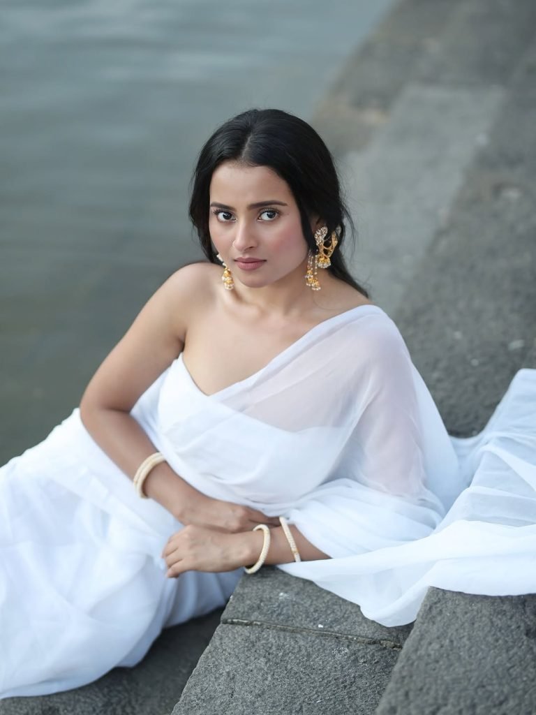 Serene portrait of Aarushi Baruah in white saree natural lake backdrop