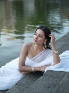 Aarushi Baruah white chiffon saree flowing by calm lakeside