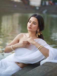 Aarushi Baruah white chiffon saree flowing by calm lakeside