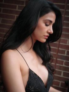 Disha Patani close-up in sleek black slip dress, confident gaze