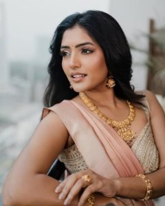 Eesha Rebba elegant pose showcasing peach saree draping and jewelry