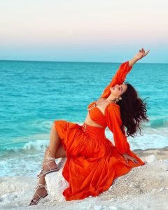 Flowing orange dress movement captured in Eshanya Maheshwari beach photo