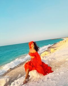 Ocean backdrop with Eshanya Maheshwari spinning in orange beach dress