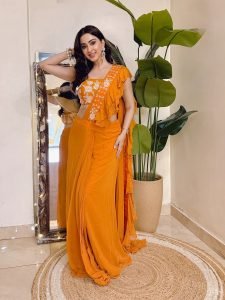 Eshanya Maheshwari cheerful smile in orange ruffle saree indoors