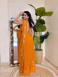Eshanya Maheshwari cheerful smile in orange ruffle saree indoors