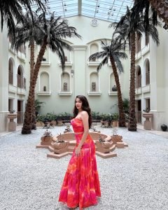 Profile shot of Eshanya Maheshwari in pink cutout dress, sunlight filtering