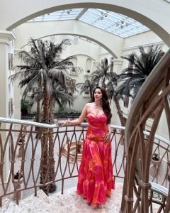 Playful pose by Eshanya Maheshwari in pink dress with city as backdrop