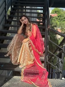 Eshanya Maheshwari red lehenga balcony natural sunlight portrait