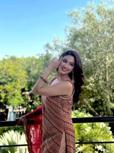 Eshanya Maheshwari twirling in red lehenga on sunny balcony