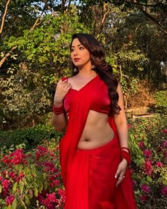 Graceful pose by Eshanya Maheshwari in a vibrant red saree outdoors
