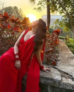 Graceful pose by Eshanya Maheshwari in a vibrant red saree outdoors