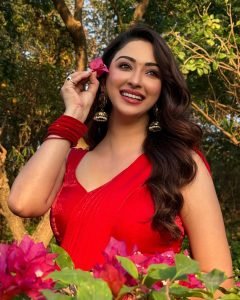 Candid shot of Eshanya Maheshwari laughing in red saree in garden setting