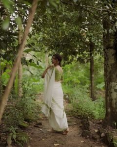 Madonna Sebastian gentle expression wearing elegant white saree