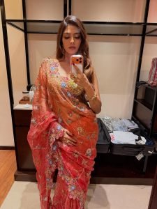 Malavika Mohanan coral floral saree against colorful mosaic wall backdrop