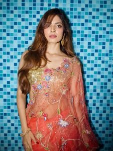 Malavika Mohanan coral floral saree against colorful mosaic wall backdrop