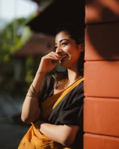 Namitha Pramod swinging in black saree with bright mustard border