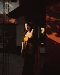 Namitha Pramod swinging in black saree with bright mustard border