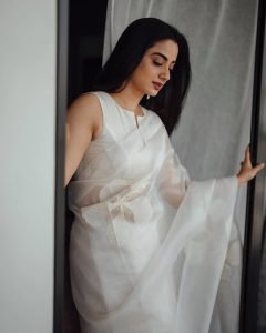 Warm lighting on Namitha Pramod elegant white saree indoors