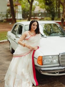 Namitha Pramod ivory saree with rose-gold jewelry in car cabin