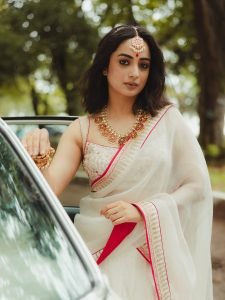 Namitha Pramod ivory saree with rose-gold jewelry in car cabin