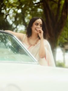 Namitha Pramod ivory saree with rose-gold jewelry in car cabin