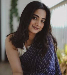 Natural light highlighting Namitha Pramod navy saree outdoor shot