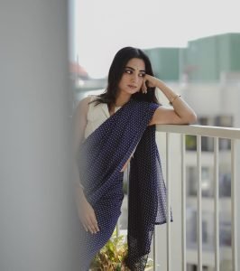 Namitha Pramod graceful balcony pose in sophisticated navy saree