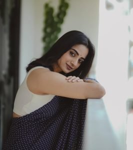 Namitha Pramod graceful balcony pose in sophisticated navy saree