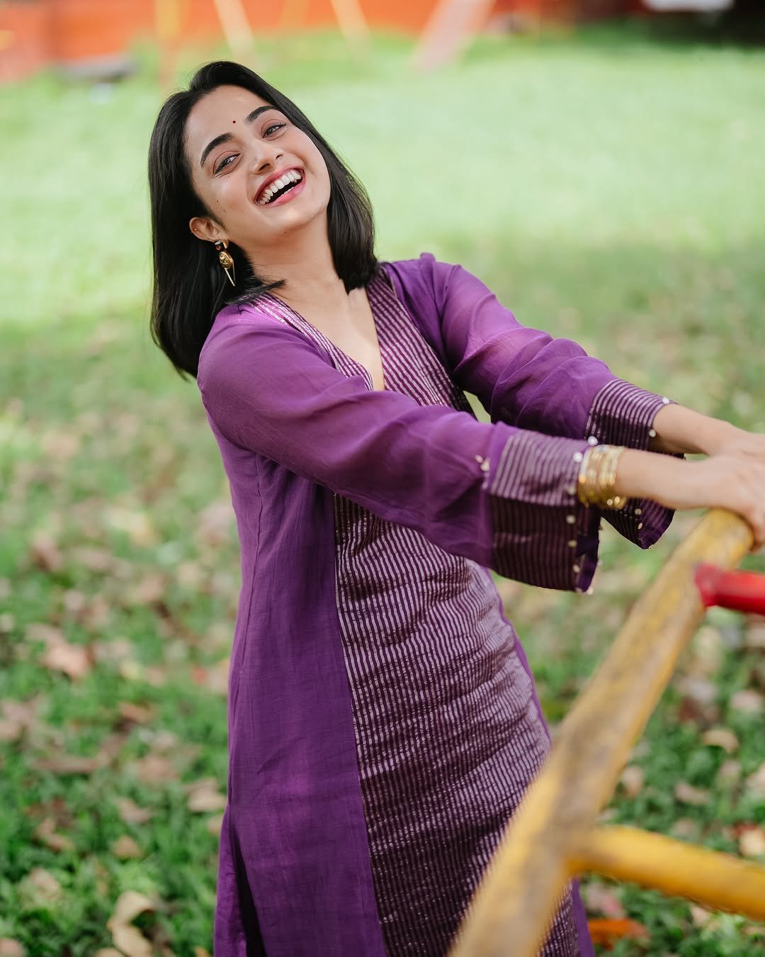 Namitha Pramod purple pleated suit garden bench radiant smile Photos (11)
