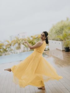 Namitha Pramod bright yellow twist dress among garden flowers