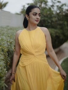 Namitha Pramod playful pose in modern yellow twist design dress