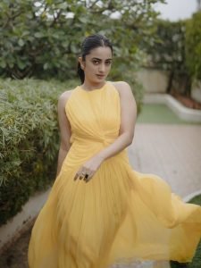 Namitha Pramod playful pose in modern yellow twist design dress